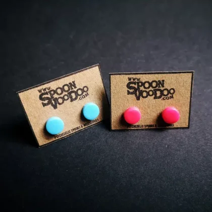 2 pairs of uv neon ear studs in pink and blue, lit under blacklight