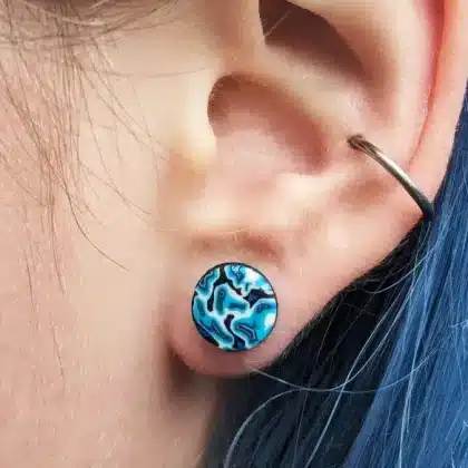 close up in situ psychedelic blue ear studs