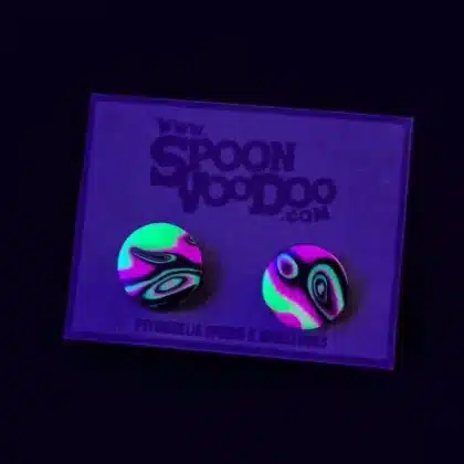 trippy uv ear studs under fluorescent UV blacklight. psychedelic festival ear jewelry